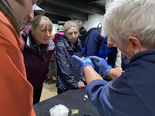 Volunteer showing a recently excavated find to Friends of Vindolanda