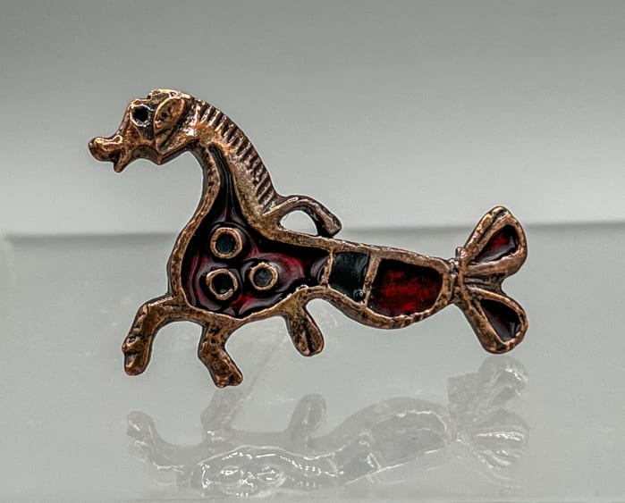 Bronze brooch with red enamel depicting a hippocamp.